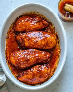 a white bowl filled with meat covered in bbq sauce