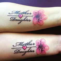 two matching tattoos with the words mother and daughter written on their arms, one is pink flowers