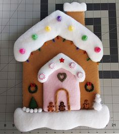 a gingerbread house is decorated with icing and christmas decorations on the front side