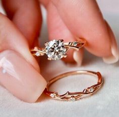 a woman's hand holding an engagement ring with a diamond on top of it