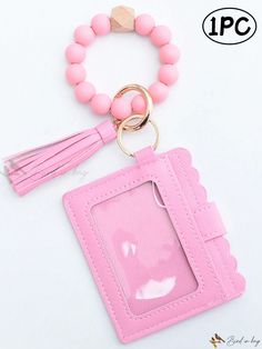 a pink card case with a tassel and keychain attached to the front