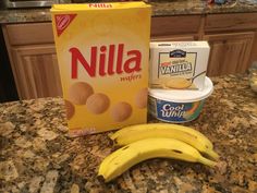 two bananas, yogurt and nut butter are on the counter top next to a carton of nilla wafers