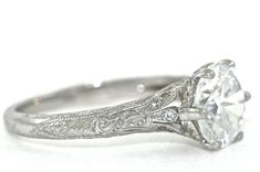 an antique style diamond engagement ring with filigrees