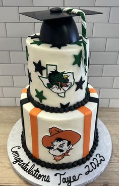 a three tiered cake with an orange and white graduation cap on top