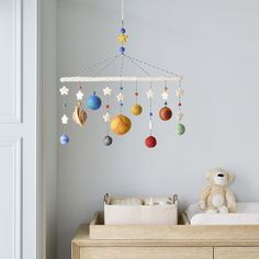 a baby crib with ornaments hanging from the ceiling