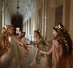 three women dressed in white dresses and gold hair are talking to each other on the hallway