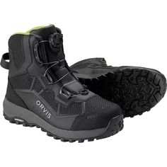 a pair of black hiking boots with green accents on the outstep and soles