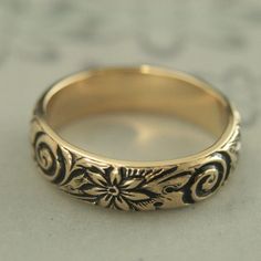 Antiqued Gold Band Antiqued Gold Ring Vintage Style Ring Vintage Style Band Gold Wedding Band Solid 14K Gold Ring Floral Band Crazy Daisy Introducing our new ANTIQUED Gold Bands! Whimsical and absolutely stunning, the embossed floral and swirl pattern encompasses the entire band with elegance and lovely detail. Measuring 5mm wide, it is a hefty 1.5mm thick. This makes it a heavy quality band to pass down for generations. You won't be disappointed! Your ring will be custom made to size just for y Antique Engraved Rings For Marriage, Heirloom Engraved Ring Stamped 14k For Marriage, Ornate Yellow Gold Jewelry With Decorative Band, Yellow Gold Engraved Band Rings, Engraved Yellow Gold Band Ring, Engraved Yellow Gold Rings For Marriage, Fine Jewelry In Yellow Gold For Marriage, Engraved Yellow Gold Marriage Ring, Fine Yellow Gold Jewelry For Marriage