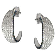 Elegant 18kt white gold hoops with diamonds and blue sapphires from Ralph Masri's Modernist collection, inspired by mid-century Modernist architecture with an emphasis on minimalist shapes and silhouettes. Available in yellow, rose or white gold. Push backs for pierced ears. Modern White Gold Hoop Earrings With Pave Setting, Modern Hoop Earrings With Pave Setting For Formal Occasions, Modern Silver Diamond Earrings, Modern Sterling Silver Diamond Earrings, Modern Single Cut Diamond Earrings, Modern Hoop Earrings With Diamond Accents, Modern Diamond White Diamond Earrings, Modern Hoop Earrings With Single Cut Diamonds, Hoops With Diamonds