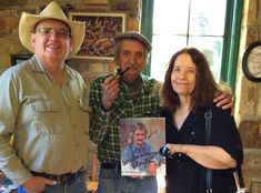 two people standing next to each other with a picture on the table in front of them