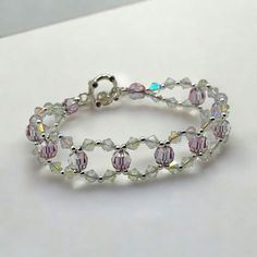 a bracelet made with swaronite and glass beads on a white table top