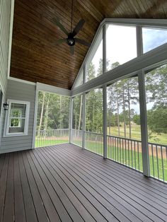 an empty porch with a ceiling fan and wood flooring on the side of it