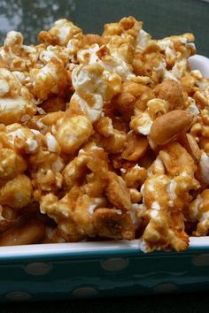 a bowl filled with caramel popcorn on top of a table