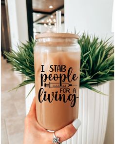 a person holding up a drink in front of a potted plant with the words a wise doctor once wrote on it