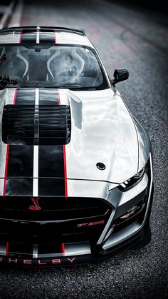 the front end of a sports car with red and white stripes