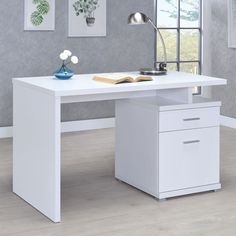 a white desk with two drawers and a lamp