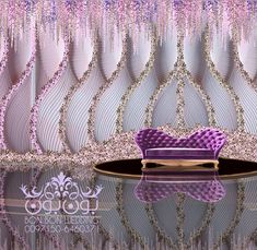 a purple couch sitting on top of a table in front of a wallpapered background