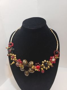 This sparkly statement necklace of deep reds (burgundy,  maroon, and wine) sits approx. 20 inches.  I made each flower from single beads, forming each flower, then attaching each to the tarnish resistant wire, placing them in an appealing combination.  She is a unique,  one-of-a-kind necklace.  The only one made.  You won't encounter anyone else with her.  I hope you love her as much as I do! Although wire is tarnish resistant,  take extra care when storing it, and, when wearing it.  Put it on after perfumes, aerosols, lotions, etc. Wire Spider, Beaded Spiders, Single Bead, Wire Necklace, Burgundy And Gold, Wire Wrapped Necklace, Necklace Beaded, Black Flower, Flower Necklace