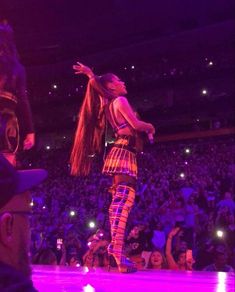 a woman standing on top of a stage in front of a crowd