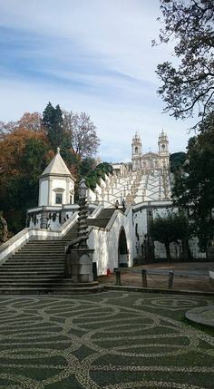 a large white building with stairs leading up to it's top and another building in the background