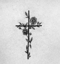 a cross with two roses on it is shown in this black and white photo,