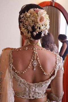 the back of a woman's dress in front of a mirror with flowers on it