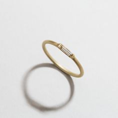 A single Diamond Baguette set in Satin finished gold. [.15ct], Recycled 14 Karat Yellow Gold Minimalist Baguette Diamond Jewelry, Minimalist Baguette Single Cut Diamond Jewelry, Minimalist Yellow Gold Baguette Jewelry, Minimalist Everyday Baguette Jewelry, Minimalist Yellow Gold Jewelry With Baguette Diamonds, Diamond Baguette, Diamond Set, Baguette Diamond, Gold Rings