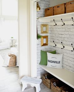 a white brick wall with shelves and baskets on the top, along with other items