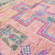 a multicolored rug is laying on top of the floor with an intricate design