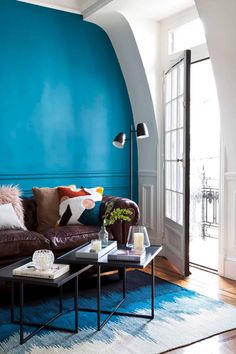 a living room with blue walls and leather furniture