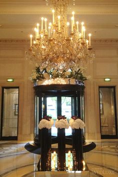 the chandelier in the lobby is decorated with flowers and greenery on display