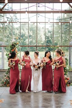 the bride and her bridesmaids pose for a photo in front of an open window