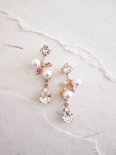 "These delicate vintage inspired earrings are made with fine Swarovski crystals and Swarovski pearls. Available in gold, silver or rose gold finish and with white or ivory pearl. Shown in the photos in rose gold finish with white pearls. - Measurements: 1 1/2\" long and 1/2\" wide at the wides point - Post earrings with butterfly ear-nuts" Rose Gold Delicate Pearl Earrings For Formal Occasions, Delicate Rose Gold Pearl Earrings For Formal Events, Delicate Rose Gold Pearl Earrings For Formal Occasions, Elegant Rose Gold Drop Bridal Earrings, Elegant Rose Gold Bridal Drop Earrings, Elegant Rose Gold Dangle Chandelier Earrings, Rose Gold Pearl Bridal Earrings For Formal Occasions, Elegant Rose Gold Bridal Earrings, Rose Gold Pearl Drop Flower Earrings