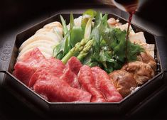 a tray filled with meat, vegetables and sauce