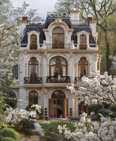 a large white house with lots of windows and balconies on the top floor