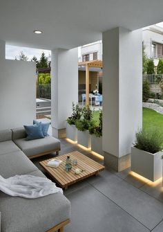 a living room filled with furniture and plants