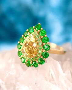 a yellow and green ring sitting on top of a rock