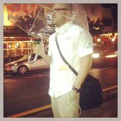 a man standing on the street holding an umbrella