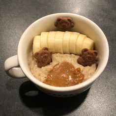 a bowl filled with oatmeal topped with bananas and teddy bear candies