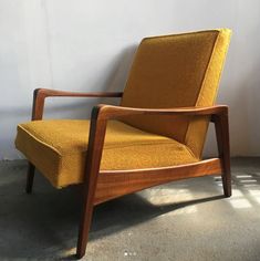 a yellow chair sitting against a white wall