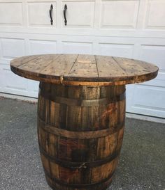 a wooden barrel table sitting in front of a garage door