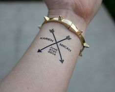 a person's wrist with an arrow tattoo on it