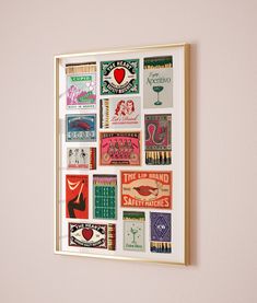 a white framed wall hanging on the side of a pink wall