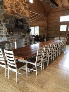 a dining room table and chairs in front of a stone fireplace