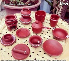 a table topped with lots of red dishes and cups