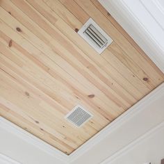 a bathroom with wood paneling and a ceiling vent