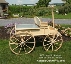 a wooden horse drawn carriage sitting in the grass