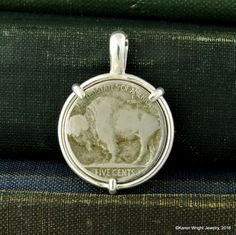 "This is a custom order item. Your order will ship within 3-5 business days of payment confirmation. The coin pendant in the listing photos is an example of the finished piece. Excluding the year on the coin, your coin pendant will be the same design as the pictured pendant. Each pendant setting is made by hand (not a machine), and no two coins are exactly alike. If you are looking for a specific year, let me know, I may have it in my collection. This Buffalo Nickel rests in a handcrafted settin Untreated Sterling Silver Collectible Jewelry, Untreated Sterling Silver Round Pendant, Silver Engraved Jewelry, Silver Engraved Jewelry For Everyday, Heirloom Style Sterling Silver Nickel-free Jewelry, Antique Untreated Sterling Silver Jewelry, Heirloom Style Nickel-free Sterling Silver Jewelry, Engraved Round Pendant Jewelry For Everyday Use, Handmade Sterling Silver Necklace For Commemoration