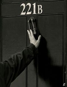 a person is holding the door handle on a black door with white lettering that reads, 22lb