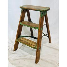 a wooden step stool sitting on top of a white sheet